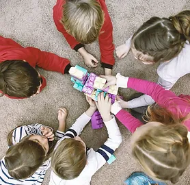 Grupo de 6 niños jugando con las manos entrelazadas